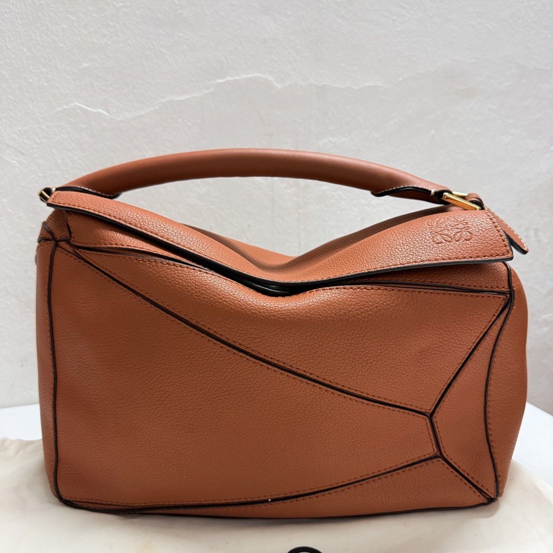Loewe Puzzle Bag Tan Leather (Category: Luxury Bags & Wallets) located in Santa Rosa. Submitted by secillanomaelisa (Listing ID 1450306937, Image 1). Description: - Loewe Puzzle Bag - Crafted from premium pebbled leather - Elegant gold hardware details - Secure zipper closure with a distinctive blue leather pull tab - Comfortable top handle for easy carrying - Spacious interior, ideal for everyday essentials - A versatile and stylish everyday com