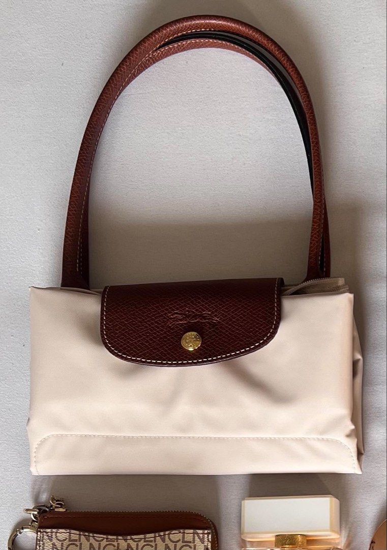Longchamp Le Pliage Tote Bag Beige (Category: Luxury Bags & Wallets) located in Las Pinas. Submitted by bcarinax (Listing ID 1450174195, Image 3). Description: - Classic Longchamp tote bag - Light beige color with brown leather trim and handles - Durable and lightweight nylon material - Spacious interior, perfect for everyday essentials or travel - Versatile and practical for various needs - Originally bought for 10,500 .