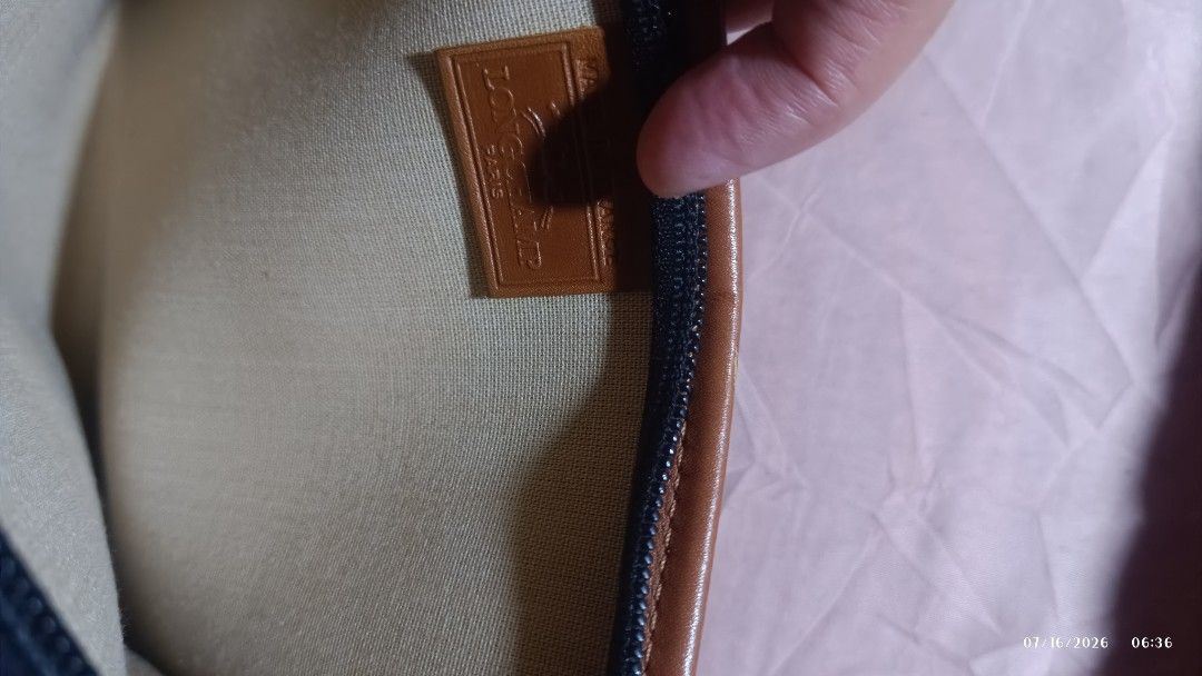 Longchamp Pouch Dark Blue with Brown Leather Trim (Category: Purses & Pouches) located in Rizal. Submitted by simplygoodthingsmel (Listing ID 1450278360, Image 1). Description: - brown pouch with a repeating pattern - Brown leather trim around the edges - Zipper closure with a metal charm - Tan interior lining - Ideal for organizing essentials.