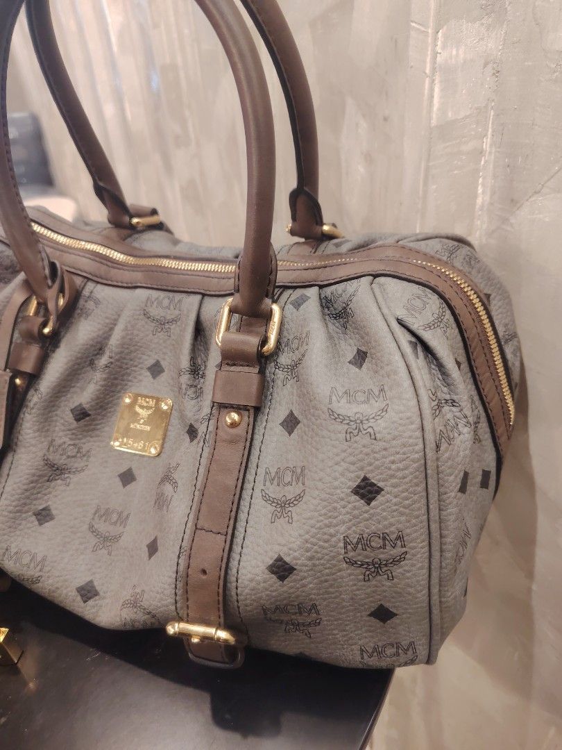 MCM Monogram Boston Bag with Lock and Keys (Category: Luxury Bags & Wallets) located in Cagayan de Oro. Submitted by michaelluxuryitems (Listing ID 1450168784, Image 2). Description: - Authentic MCM monogram Boston bag - Features brown leather trim and handles - Comes with original lock and keys - Secure zipper closure - Spacious interior for everyday essentials - Ideal for daily use.