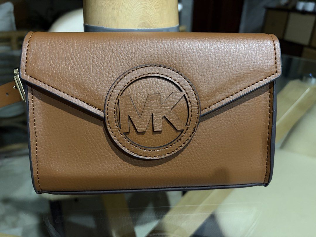 Michael Kors Brown Leather Belt Bag (Category: Luxury Bags & Wallets) located in Manila. Submitted by ejshop82 (Listing ID 1450282773, Image 1). Description: - Authentic Michael Kors brown leather belt bag - Features iconic MK logo on the front - Secure magnetic closure - Adjustable belt strap for a comfortable fit - Size L/XL - Perfect for hands-free convenience.