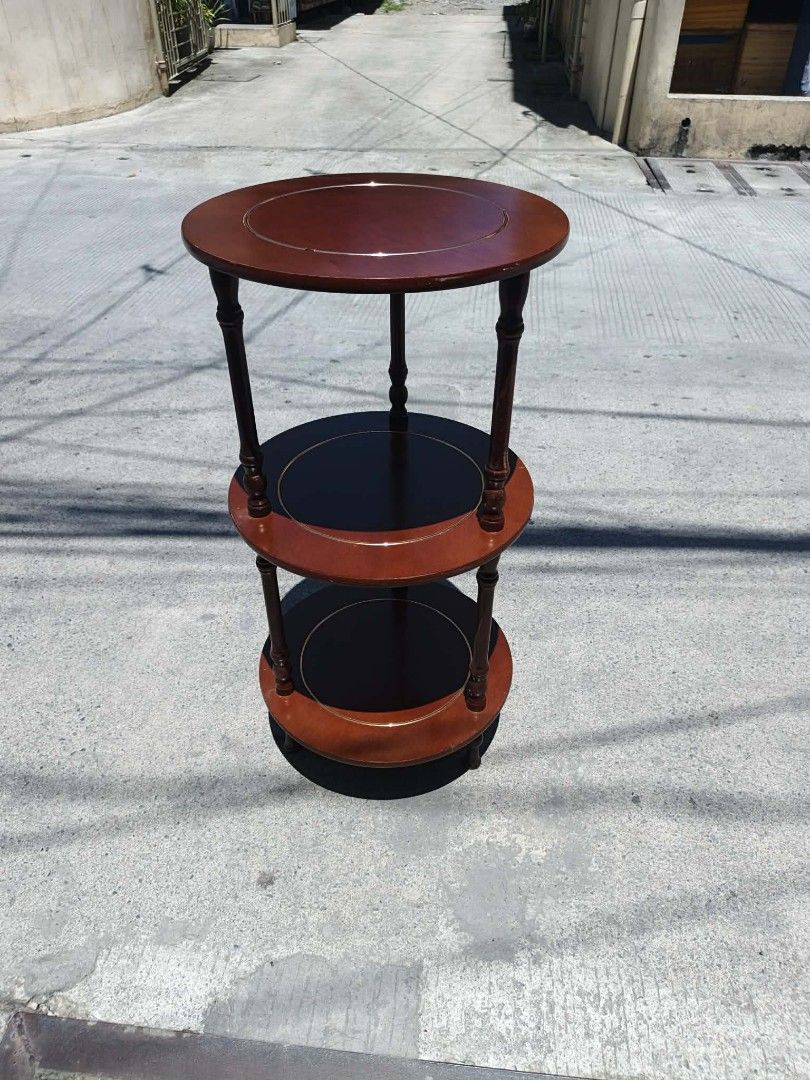 Mid century Wooden 3-Tier Round Side Table (Category: Tables & Sets) located in Valenzuela. Submitted by mariteskendra012917 (Listing ID 1450151817, Image 2). Description: - Elegant 3-tier round side table - Rich dark wood finish with contrasting lighter wood accents - Top and bottom tiers are solid wood - Middle tier features a dark wood insert - Ideal for holding drinks, books, plants, or decorative items - Dimensions: Height 76cm, Diameter 38c