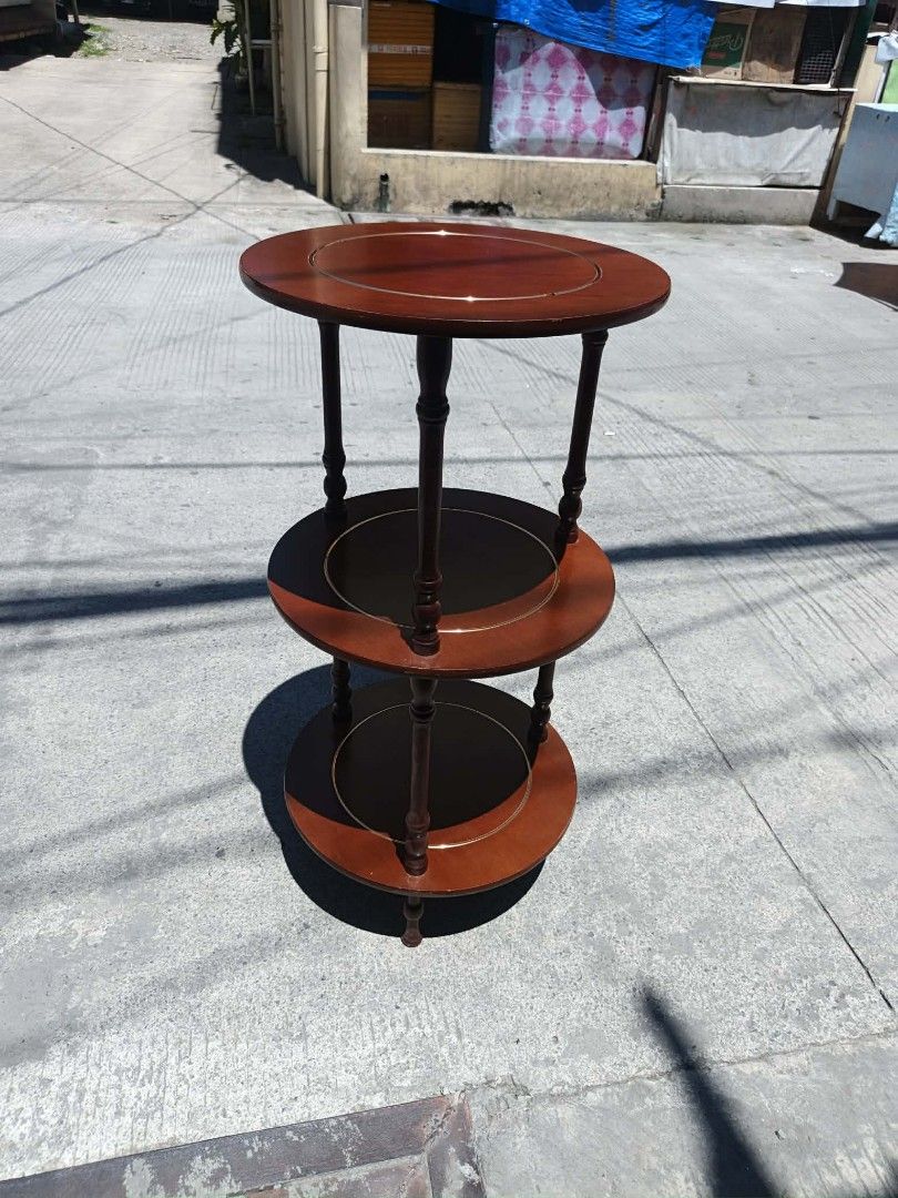 Mid century Wooden 3-Tier Round Side Table (Category: Tables & Sets) located in Valenzuela. Submitted by mariteskendra012917 (Listing ID 1450151817, Image 3). Description: - Elegant 3-tier round side table - Rich dark wood finish with contrasting lighter wood accents - Top and bottom tiers are solid wood - Middle tier features a dark wood insert - Ideal for holding drinks, books, plants, or decorative items - Dimensions: Height 76cm, Diameter 38c