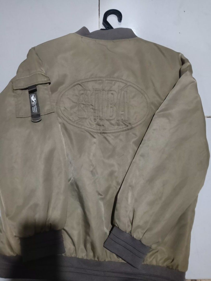 NBA Bomber Jacket (Category: Coats, Jackets and Outerwear) located in Kuala Lumpur. Submitted by fikri5588 (Listing ID 1450247350, Image 2). Description: - Stylish brown NBA bomber jacket - Features NBA logo on the front - Large embroidered NBA logo on the back - Zipper closure for easy wear - Ribbed cuffs and hem for a snug fit - Tag indicates size 150 - Ideal for any basketball or NBA enthusiast.
