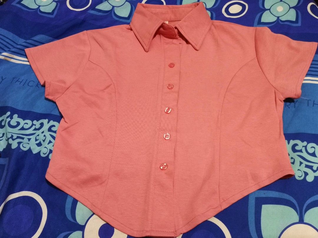 Pink Short Sleeve Collared Button-Up Shirt (M-XL) (Category: Shirts) located in Lopez. Submitted by declutteringcouchpotato (Listing ID 1450316537, Image 1). Description: - Adorable pink collared shirt - Short sleeves - Button-up front closure - Subtle textured fabric - Shaped seams for a flattering fitted look - Asymmetrical hemline (longer front and back) - Versatile for casual or dressed-up outfits.
