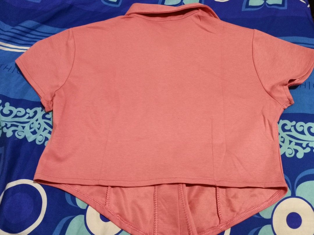 Pink Short Sleeve Collared Button-Up Shirt (M-XL) (Category: Shirts) located in Lopez. Submitted by declutteringcouchpotato (Listing ID 1450316537, Image 2). Description: - Adorable pink collared shirt - Short sleeves - Button-up front closure - Subtle textured fabric - Shaped seams for a flattering fitted look - Asymmetrical hemline (longer front and back) - Versatile for casual or dressed-up outfits.