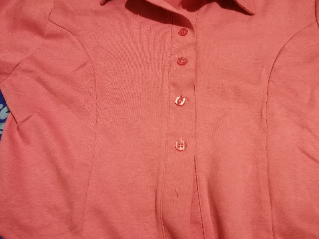 Pink Short Sleeve Collared Button-Up Shirt (M-XL) (Category: Shirts) located in Lopez. Submitted by declutteringcouchpotato (Listing ID 1450316537, Image 3). Description: - Adorable pink collared shirt - Short sleeves - Button-up front closure - Subtle textured fabric - Shaped seams for a flattering fitted look - Asymmetrical hemline (longer front and back) - Versatile for casual or dressed-up outfits.