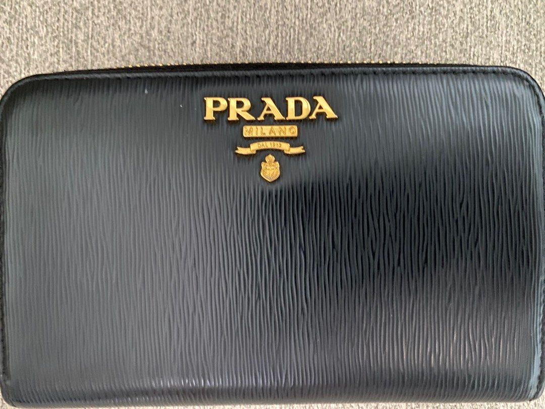 Prada Black Leather Zip Around Wallet (Category: Luxury Bags & Wallets) located in Pasig City. Submitted by greatlookforless (Listing ID 1450193790, Image 2). Description: - Authentic Prada wallet NEW ・With gold logo ・Round zipper closure ・2 gusseted compartments ・4 card pockets ・2 multi-pockets ・1 zippered coin purse ・1 back zippered pocket (one-sided gusset) ・Gold hardware - natural durable leather - Lampo special zipper Size Width 15cm x Heigh