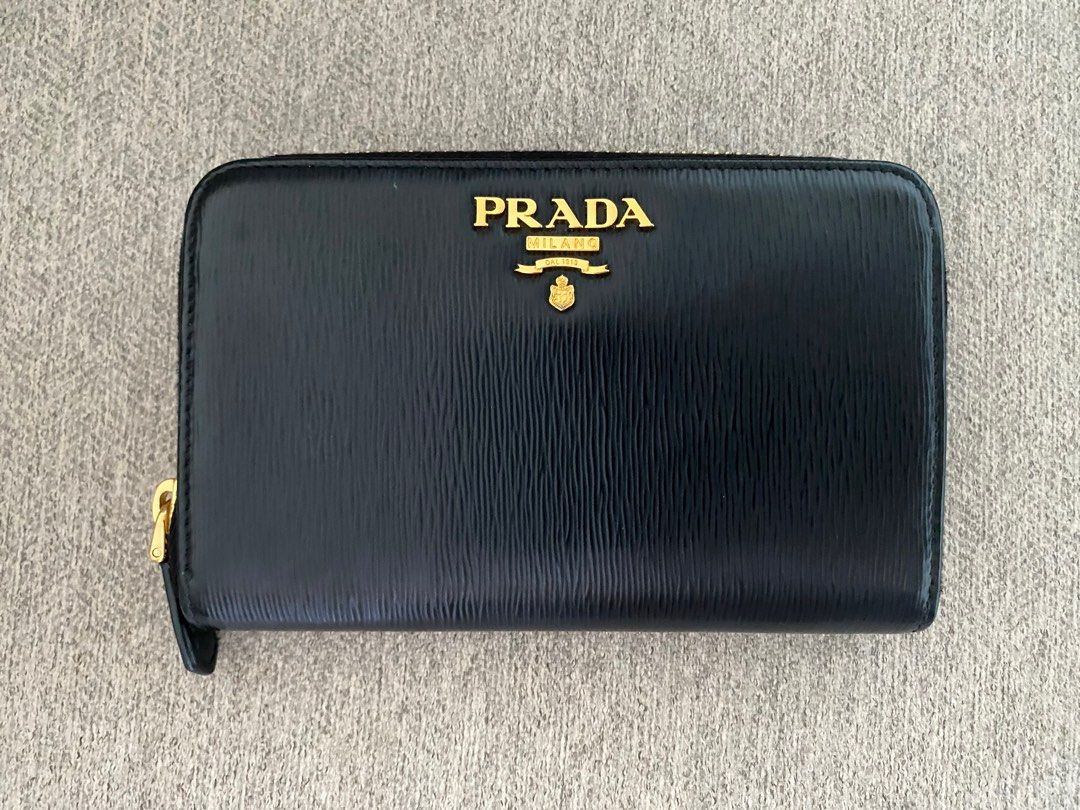 Prada Black Leather Zip Around Wallet (Category: Luxury Bags & Wallets) located in Pasig City. Submitted by greatlookforless (Listing ID 1450193790, Image 1). Description: - Authentic Prada wallet NEW ・With gold logo ・Round zipper closure ・2 gusseted compartments ・4 card pockets ・2 multi-pockets ・1 zippered coin purse ・1 back zippered pocket (one-sided gusset) ・Gold hardware - natural durable leather - Lampo special zipper Size Width 15cm x Heigh