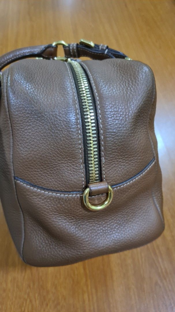 Prada Brown Leather Satchel Bag with Lock and Key (Category: Luxury Bags & Wallets) located in Manila. Submitted by lc_declut (Listing ID 1450148839, Image 3). Description: - Genuine brown pebbled leather Prada satchel - Elegant gold hardware details - Includes original dust bag, authenticity cards, lock, and key - Interior features a zippered pocket and a slip pocket - Protective feet on the bottom for durability - Ideal for everyday use.