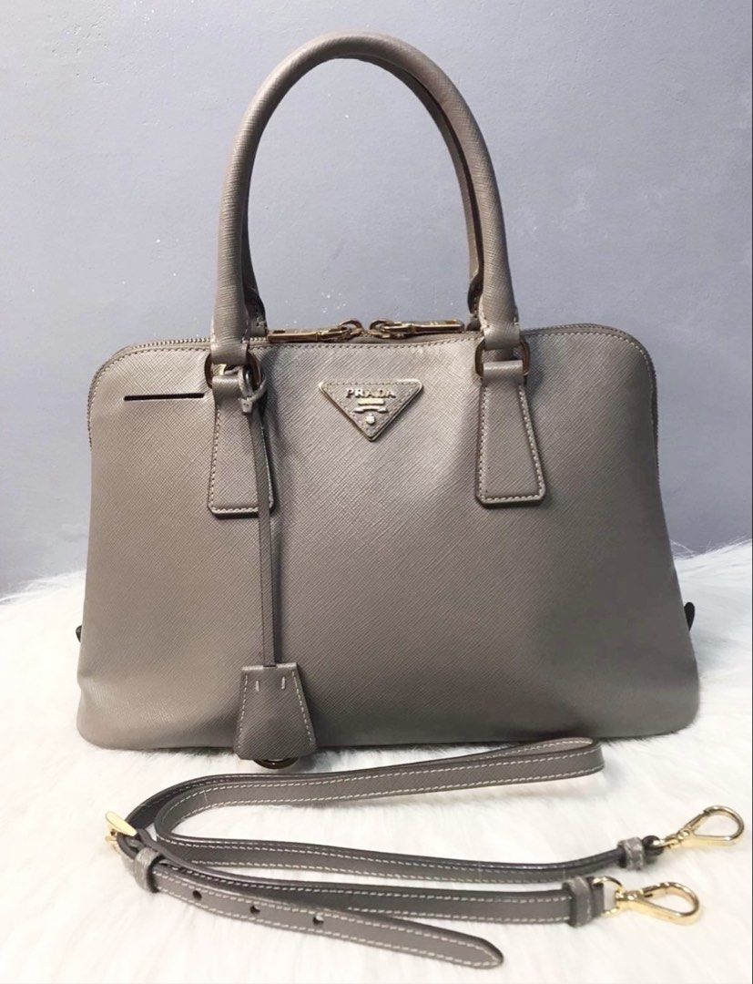 Prada Saffiano Leather Grey Top Handle Bag (Category: Luxury Bags & Wallets) located in Las Pinas. Submitted by CocoBebeBeautiQ (Listing ID 1450216001, Image 1). Description: Authentic Prada Saffiano leather bag grey color Detachable shoulder strap included Interior features Prada logo lining Comes with Entrupy certificate of authenticity tag 64 PAYMENT FIRST POLICY PASS TO LOW BALLER.