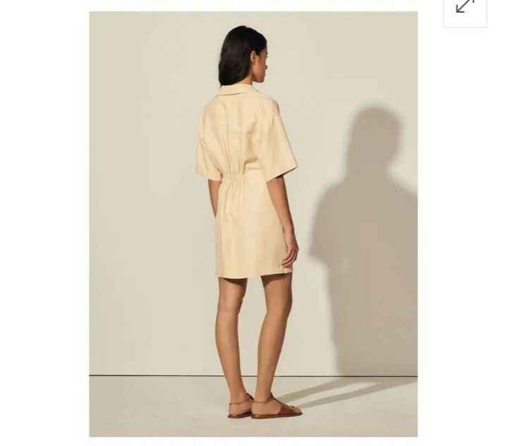 Sandro Beige draped Twisted Shirt Dress (Category: Luxury Apparel) located in Makati City. Submitted by lilsuzies (Listing ID 1450290855, Image 3). Description: -authentic - Beige Sandro shirt dress - bust 36 waistline 28-32 Length33. 5 - Short sleeves - Collared neckline - Unique twisted detail at the waist - Gold-tone buttons with Sandro logo - Versatile for dressing up or down - Perfect for a chic, casual look.
