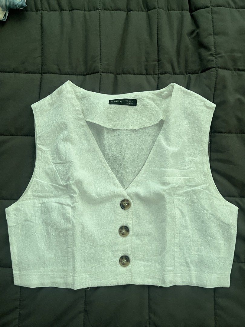 SHEIN White Cropped Button-Up Vest Top Size S (Category: Sleeveless) located in Cavite. Submitted by Djbstuff (Listing ID 1450205644, Image 1). Description: - White cropped vest from SHEIN - V-neck with button-up front - Textured fabric - Estimated size S - Ideal for layering over tops or dresses - Versatile wardrobe addition.