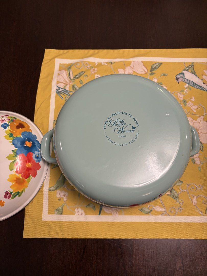 The Pioneer Woman Enamel Dutch Oven Floral Design (Category: Cookware & Accessories) located in Kuala Lumpur. Submitted by harithniall (Listing ID 1450271744, Image 2). Description: - Adorable floral Dutch oven from The Pioneer Woman. - Features charming light blue handles and trim. - Clean white interior. - Perfect for cooking soups, stews, or baking delicious treats. - Generous size: approximately 10 inches in diameter. - A lovely addition to a