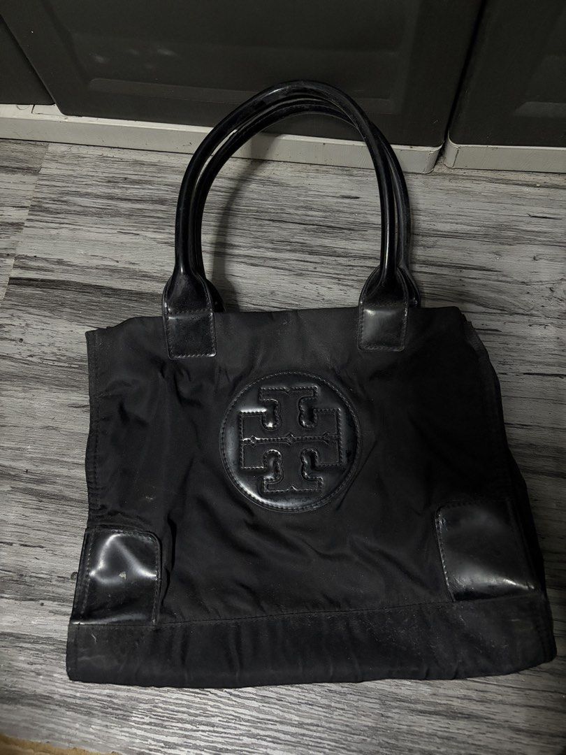 Tory Burch Black Nylon Tote Bag (Category: Luxury Bags & Wallets) located in Manila. Submitted by angelrose0210 (Listing ID 1450225167, Image 1). Description: - Classic black Tory Burch tote bag - Durable nylon with leather accents - Spacious interior with zippered pocket and central divider - Shiny black handles - Minor signs of wear on interior lining and exterior leather trim.