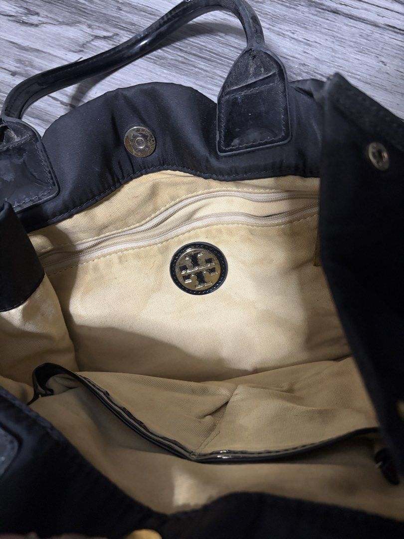 Tory Burch Black Nylon Tote Bag (Category: Luxury Bags & Wallets) located in Manila. Submitted by angelrose0210 (Listing ID 1450225167, Image 3). Description: - Classic black Tory Burch tote bag - Durable nylon with leather accents - Spacious interior with zippered pocket and central divider - Shiny black handles - Minor signs of wear on interior lining and exterior leather trim.