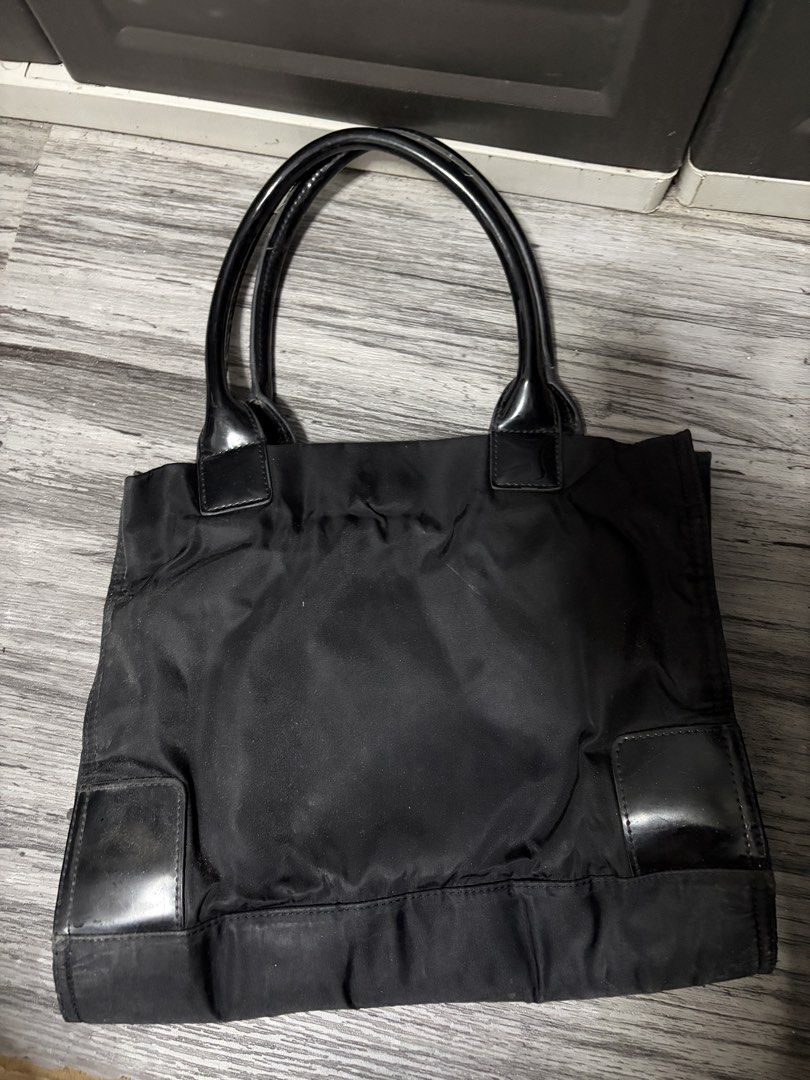 Tory Burch Black Nylon Tote Bag (Category: Luxury Bags & Wallets) located in Manila. Submitted by angelrose0210 (Listing ID 1450225167, Image 2). Description: - Classic black Tory Burch tote bag - Durable nylon with leather accents - Spacious interior with zippered pocket and central divider - Shiny black handles - Minor signs of wear on interior lining and exterior leather trim.