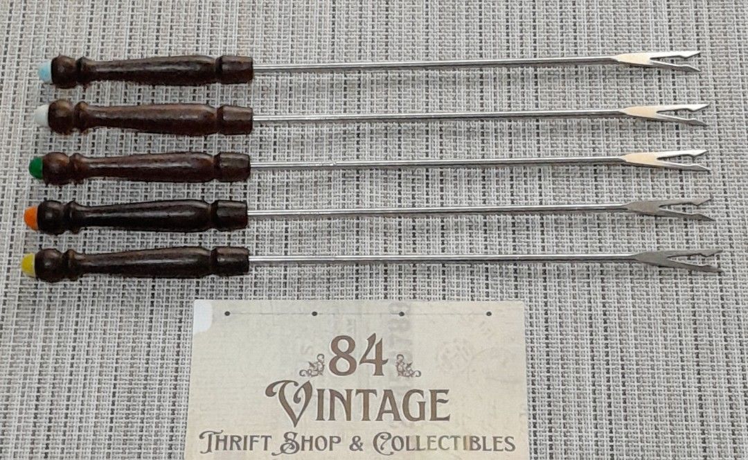 Vintage Fondue Forks (Category: Dinnerware & Cutlery) located in Las Pinas. Submitted by 84vintage (Listing ID 1450203074, Image 1). Description: Sold As set. As Is Where Is Only. These vintage fondue forks feature dark teak wooden handles and stainless steel shafts. Each fork is tipped with a distinct colored plastic button to identify individual users during a meal. The set is suitable for dipping fruit, meat, brownies, or marshmallows into che