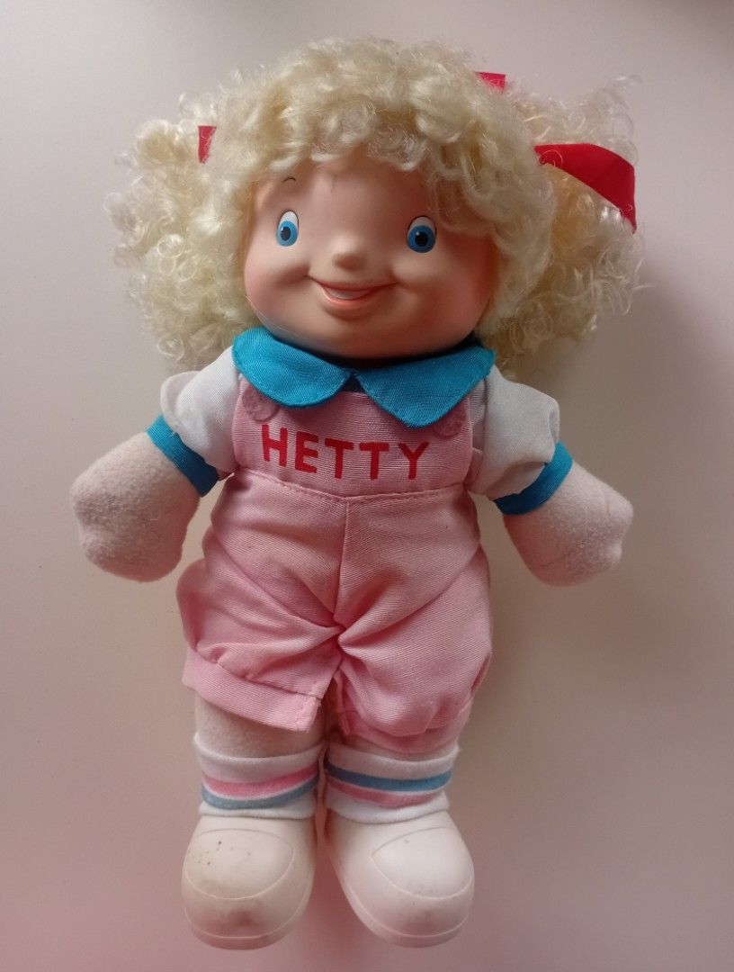 Vintage Jollibee Hetty Doll 1994 (Category: Plushies & Soft Toys) located in Navotas City. Submitted by ms.soulana (Listing ID 1450295876, Image 1). Description: -PreOwned LikeNew Vintage Jollibee Hetty Doll from 1994 - Features a vinyl head and soft plush body - Adorable curly blonde hair adorned with red bows - Pink overalls with 'HETTY' embroidered on the front - Approximately 13 inches tall - Perfect for collectors and Jollibee fans! Great Co