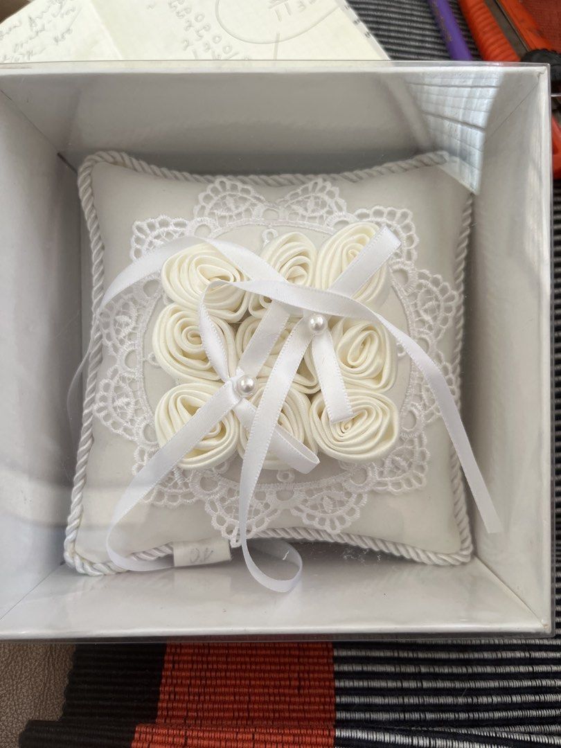 White Ring Pillow with Rosettes and Lace (Category: Bedding & Towels) located in Los Banos. Submitted by profemy (Listing ID 1450221565, Image 1). Description: - Beautiful white ring pillow, perfect for weddings. - Adorned with delicate rosettes and elegant lace trim. - Includes satin ribbons and charming pearl accents. - Designed to beautifully hold your wedding rings. - Comes in its original packaging. Will ship by J& T. Add 60 pesos for shippi