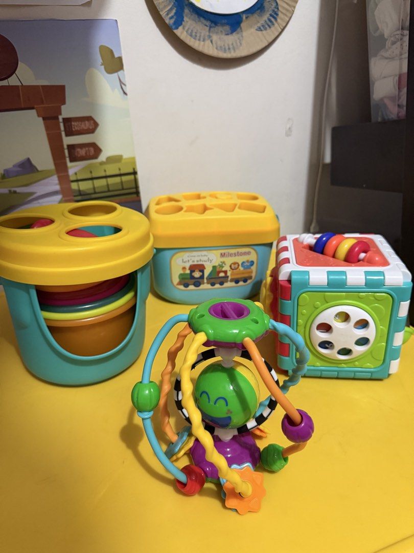 Baby Activity Toys Bundle - Stacking Cups, Shape Sorter, Activity Cube (Category: Infant Playtime) located in Pasig City. Submitted by etcyshop (Listing ID 1450348605, Image 1). Description: Preloved Batch 1 Kids educational toys for 18mos- 3y/o Item #1 Little Learner Activity Sensory Ball- colorful developmental toy featuring a central spinning face and easy-grasp textured rings. 150 Item #2 6-sided activity cube, designed to help toddlers devel
