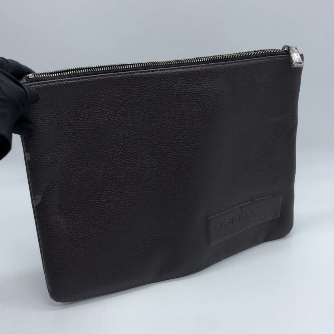 CALVIN KLAIN BROWN LEATHER CLUTCH (Category: Luxury Bags & Wallets) located in Taguig. Submitted by ecoring.ph (Listing ID 1450434992, Image 1). Description: ◆CONDITION: B- ◆DESCRIPTIONS: (Other defects/info:) OUTER: The body of the clutch has scratches, scuff marks, stains, dirt, wrinkles, press marks, peeling, deformation, and shows signs of use. The topline of the clutch also has scratches, scuff marks, stains, dirt, press marks, wrinkles, and