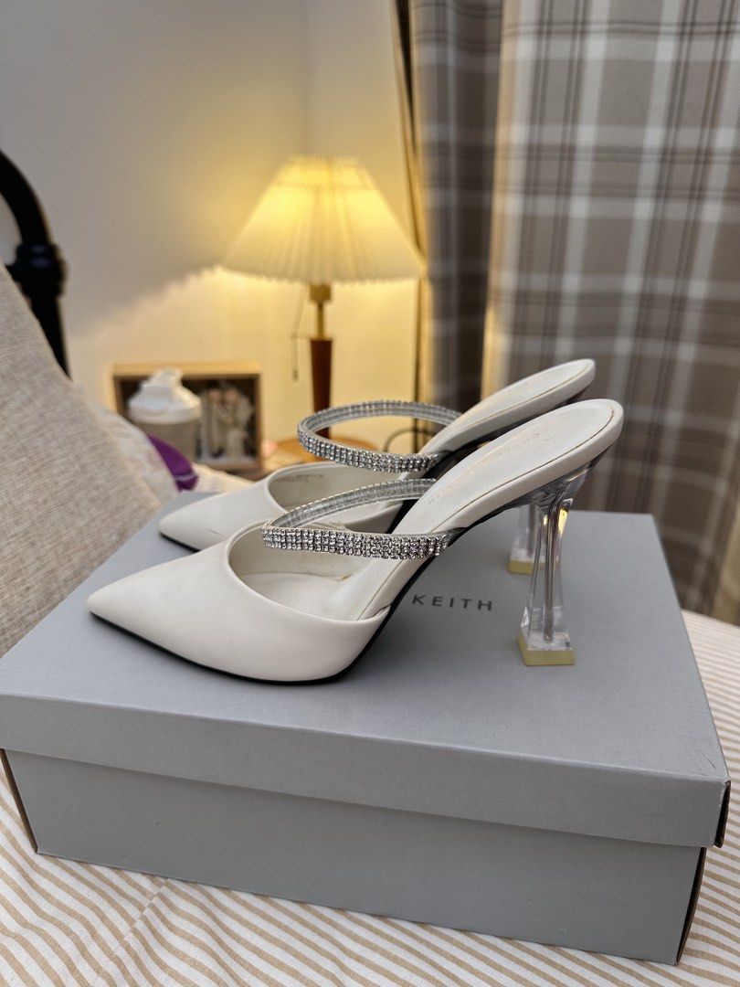 Charles & Keith White Mules with Rhinestone Strap and Clear Heel (Category: Heels) located in Kuala Lumpur. Submitted by ntsharusli (Listing ID 1450424139, Image 2). Description: - Brand: Charles & Keith - Style: White pointed-toe mules - Size: 38 - Features: Sparkly rhinestone strap, clear sculpted heel - Closure: Slip-on - Condition: Comes with original box.