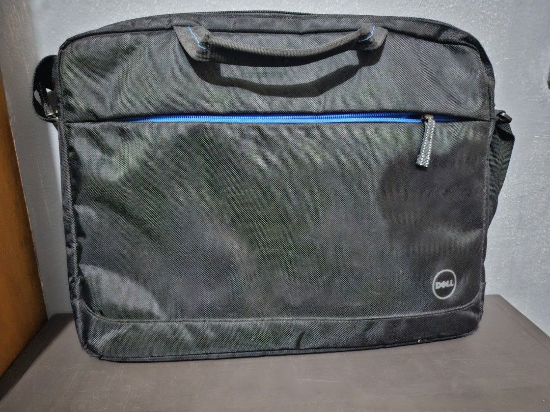 Dell Laptop Bag Messenger Bag (Category: Laptop Bags & Sleeves) located in Angeles City. Submitted by buxom.cheeks (Listing ID 1450352618, Image 1). Description: - Black Dell laptop bag - Blue zipper accent - Top handle and shoulder strap included - Spacious interior for laptop and accessories - Ideal for work or school - Shows some signs of wear, but fully functional.
