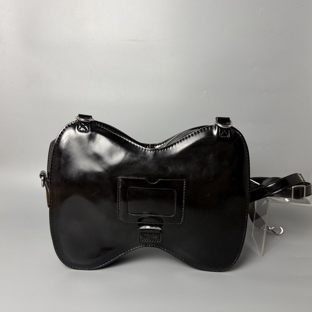 Dr. Martens Patent Leather Saddle Bag Black (Category: Luxury Bags & Wallets) located in Malasiqui. Submitted by fosh0fosh0 (Listing ID 1450341217, Image 2). Description: - Brand: Dr. Martens - Material: Black patent leather - Style: Unique saddle bag shape - Features: Eye-catching design, buckle closure front pocket, zip main compartment, adjustable strap - Finish: Shiny - Versatile: Great for everyday use or nights out.