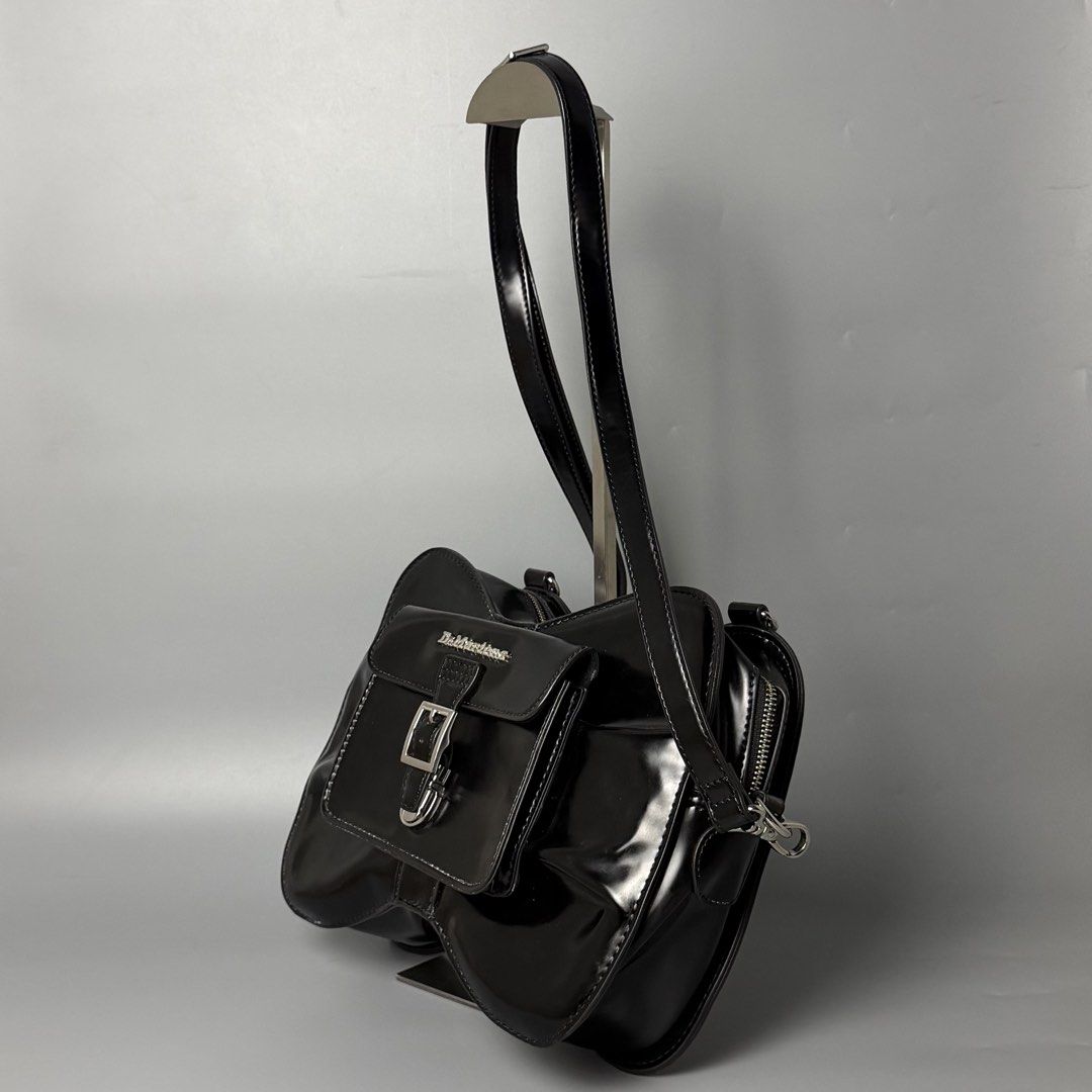 Dr. Martens Patent Leather Saddle Bag Black (Category: Luxury Bags & Wallets) located in Malasiqui. Submitted by fosh0fosh0 (Listing ID 1450341217, Image 3). Description: - Brand: Dr. Martens - Material: Black patent leather - Style: Unique saddle bag shape - Features: Eye-catching design, buckle closure front pocket, zip main compartment, adjustable strap - Finish: Shiny - Versatile: Great for everyday use or nights out.