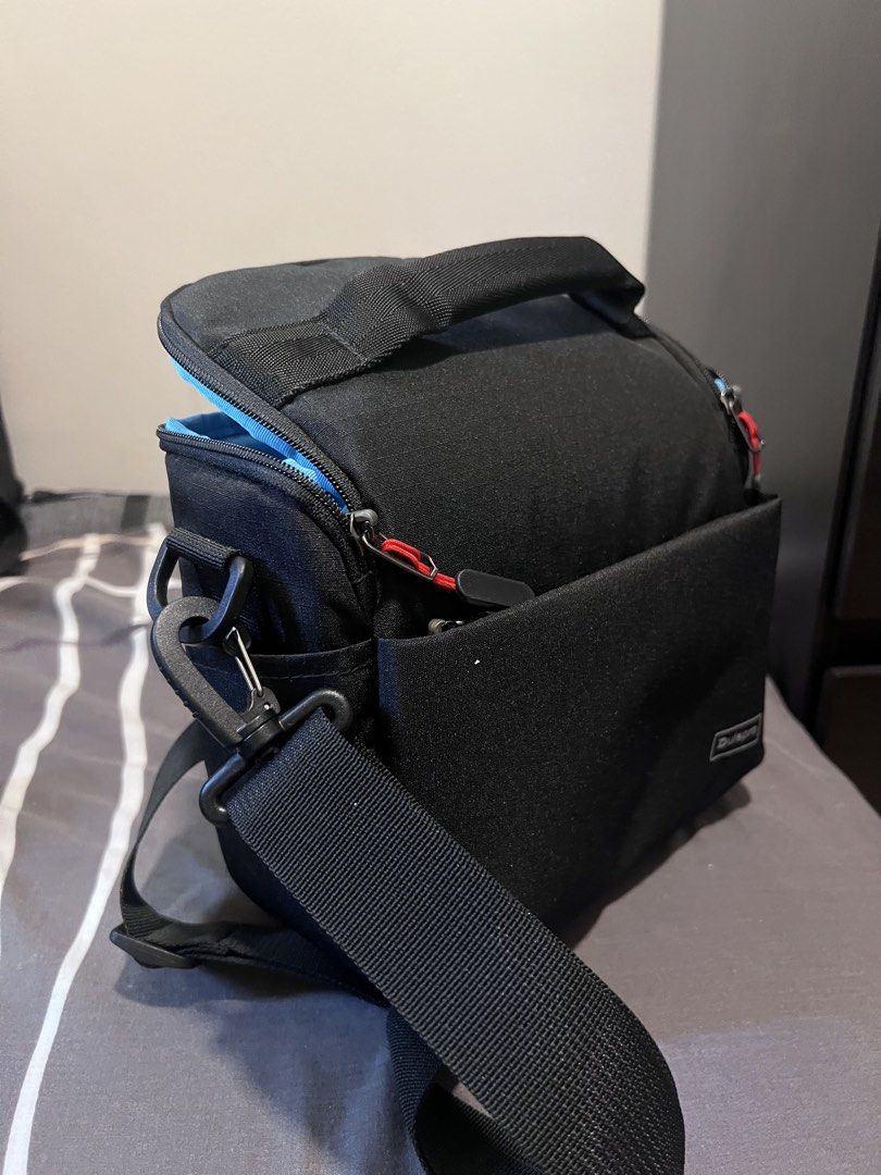 Dulepro Black Camera Bag (Category: Camera Bags & Carriers) located in Makati City. Submitted by bonjamora (Listing ID 1450407532, Image 3). Description: - Brand: Dulepro - USED ONCE - Color: Black exterior, bright blue interior lining - Main compartment: Padded with adjustable dividers - Additional storage: Front pocket for accessories - Strap: Adjustable shoulder strap included - Ideal for: Small cameras and lenses.