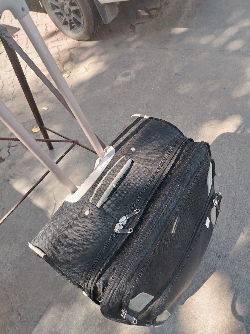 ECHOLAC Black Expandable Rolling Suitcase with Telescopic Handle (Category: Luggage) located in Manila. Submitted by purediamond888 (Listing ID 1450421736, Image 3). Description: - Black rolling suitcase - Telescopic handle for easy transport - Expandable design for extra packing space - Two front zippered pockets - Four spinner wheels for smooth movement - Shows some scuffs and marks from normal use - Great for travel.