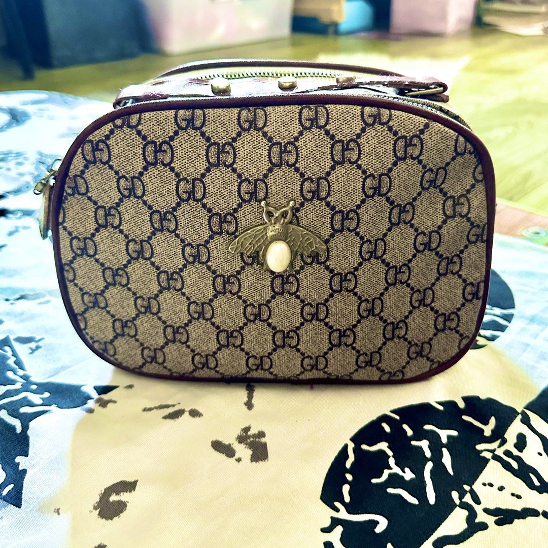 GD Monogram Bee Charm Handbag (Category: Luxury Bags & Wallets) located in Talavera. Submitted by elledepartment (Listing ID 1450378095, Image 1). Description: Cute little handbag with GD monogram print. Has a bee charm on the front. Zipper closure. The interior is spacious. Perfect for carrying essentials. Burgundy trim and gold hardware. Great for daily use. Issue: No sling bag. Free only, just buy atleast one on my listings..