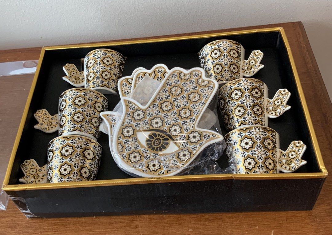 Hamsa Hand Evil Eye Coffee Cup and Saucer Set (Category: Coffee & Tea Tableware) located in Makati City. Submitted by nfb1234 (Listing ID 1450347256, Image 2). Description: - Set of 6 coffee cups and saucers - Features a Hamsa hand design with an evil eye in the center - Detailed gold and black pattern on cups and saucers - Comes in a beautiful presentation box - Ideal for serving espresso or Turkish coffee RFS - declutter .