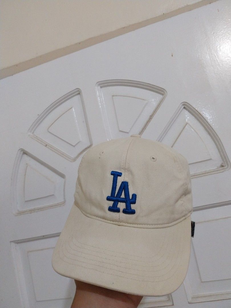 LA Dodgers Baseball Cap (Category: Caps & Hats) located in Davao. Submitted by thegraildept2026 (Listing ID 1450391374, Image 1). Description: - Cream colored cap - Blue LA logo - MLB branding inside - Adjustable strap at the back - Great for sunny days or completing an outfit - Shows some signs of wear, but still has plenty of life left.