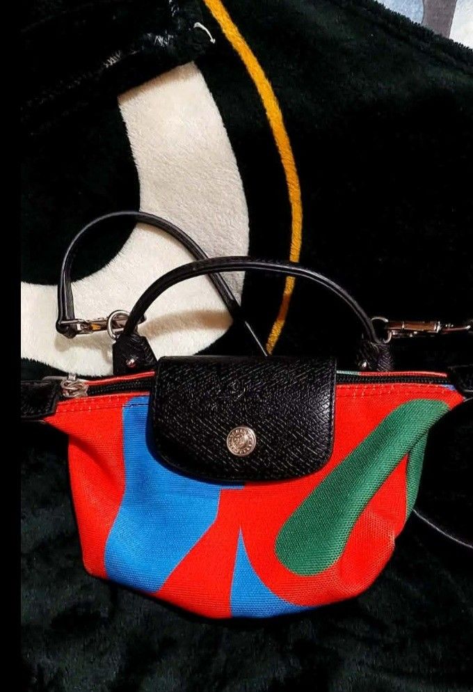 Longchamp Le Pliage Cuir Small Top Handle Bag (Category: Luxury Bags & Wallets) located in Bay. Submitted by silverhorse-59c851 (Listing ID 1450324227, Image 1). Description: - Cute and small Longchamp bag - Colorful abstract print on durable canvas - Black leather trim for a stylish finish - Comfortable top handles - Includes a detachable shoulder strap for versatility - Secure zipper closure - Authentically made in France - Ideal size for carry