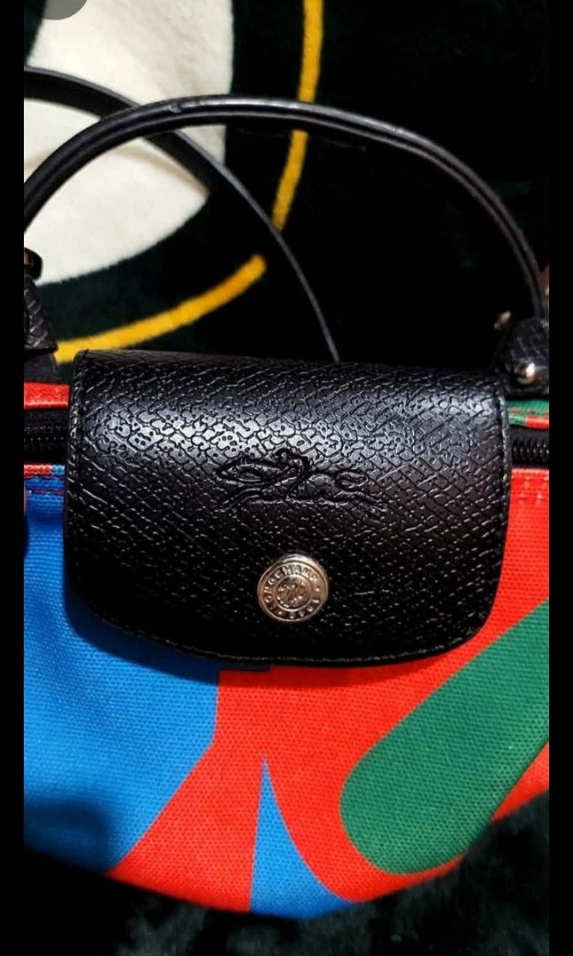 Longchamp Le Pliage Cuir Small Top Handle Bag (Category: Luxury Bags & Wallets) located in Bay. Submitted by silverhorse-59c851 (Listing ID 1450324227, Image 2). Description: - Cute and small Longchamp bag - Colorful abstract print on durable canvas - Black leather trim for a stylish finish - Comfortable top handles - Includes a detachable shoulder strap for versatility - Secure zipper closure - Authentically made in France - Ideal size for carry