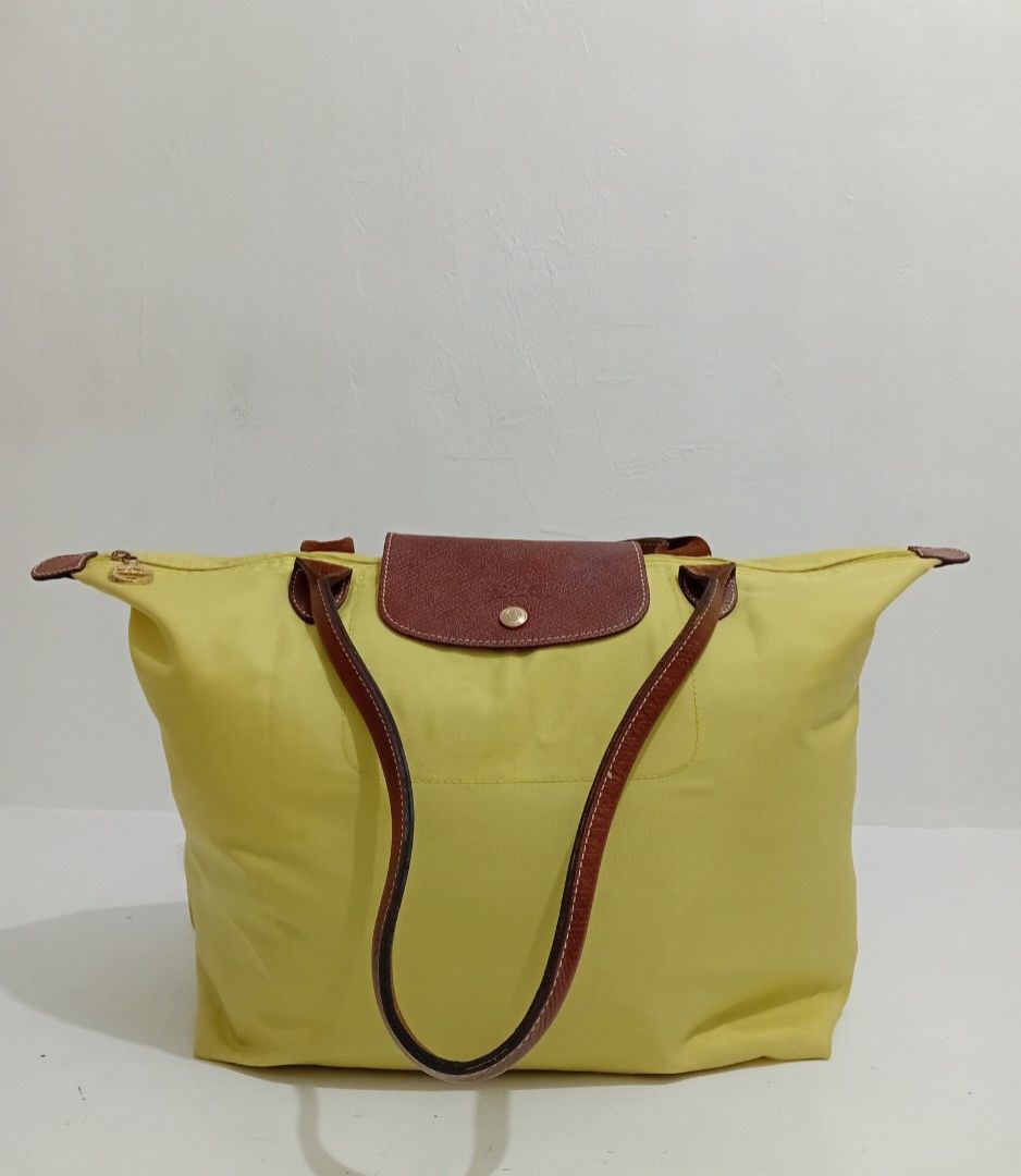 Longchamp Pliage. Original large Shoulder Tote Bag - Yellow (Category: Luxury Bags & Wallets) located in Navotas City. Submitted by riyuwi (Listing ID 1450509231, Image 3). Description: PreOwned Lightly Used Authentic Classic yellow Longchamp Pliage Original. Large Shoulder tote bag -long handle. Strap - Genuine leather handles and trim - Secure Ykk zipper closure with snap button flap (ORIGINAL .PRYM wth Hard jelly tag intact inside - Large, spa