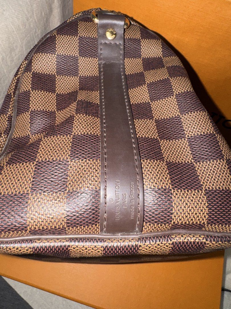 Louis Vuitton Speedy Damier Ebene Canvas Bag (Category: Luxury Bags & Wallets) located in Lipa City. Submitted by blossom_kris (Listing ID 1450374593, Image 2). Description: - Authentic Louis Vuitton Speedy 25 Bag -Speedy Bandoulière 25 -Damier Ebene canvas - Top Handles & Removable Shoulder Strap - Includes Original Lock, Keys, and Dust Bag, Receipt, - Vibrant Red Interior - Ideal for Daily Use or Travel.