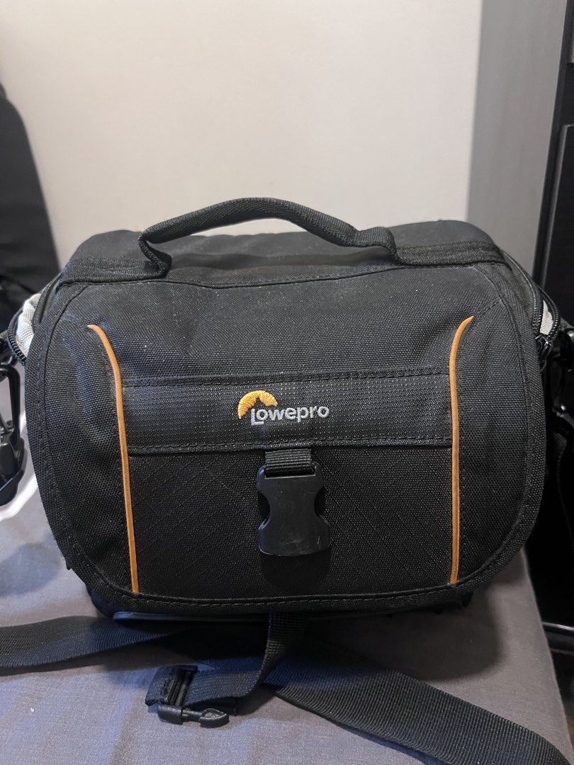 Lowepro Camera Bag (Category: Camera Bags & Carriers) located in Makati City. Submitted by bonjamora (Listing ID 1450368626, Image 1). Description: - Brand: Lowepro - Color: Black with orange trim - Interior: Adjustable dividers for camera and lenses - Features: Small zippered pocket inside lid - Includes: Shoulder strap - Benefit: Excellent protection for your camera gear.