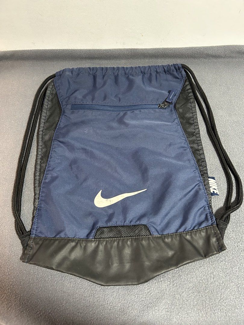 Nike Navy Blue Drawstring Bag with Zipper Pocket (Category: Backpacks) located in Baguio. Submitted by tristanzachary (Listing ID 1450519183, Image 1). Description: - Navy blue Nike drawstring bag - Front zipper pocket for extra storage - Mesh panels on the sides - Black faux leather bottom - Ideal for gym or everyday use - Drawstrings are in good working condition.