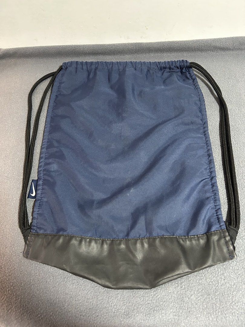 Nike Navy Blue Drawstring Bag with Zipper Pocket (Category: Backpacks) located in Baguio. Submitted by tristanzachary (Listing ID 1450519183, Image 2). Description: - Navy blue Nike drawstring bag - Front zipper pocket for extra storage - Mesh panels on the sides - Black faux leather bottom - Ideal for gym or everyday use - Drawstrings are in good working condition.