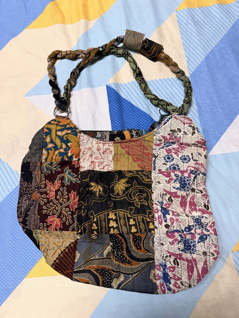 Patchwork Batik Shoulder Bag with Flower Detail (Category: Shoulder Bags) located in Paranaque City. Submitted by keyas.preloved (Listing ID 1450486375, Image 2). Description: - Unique shoulder bag made from colorful batik fabric patches. - Features a braided strap. - Decorative fabric flower with button center on the front. - Secure zipper closure. - Lined interior. - Adds a vibrant pop of color to any outfit..