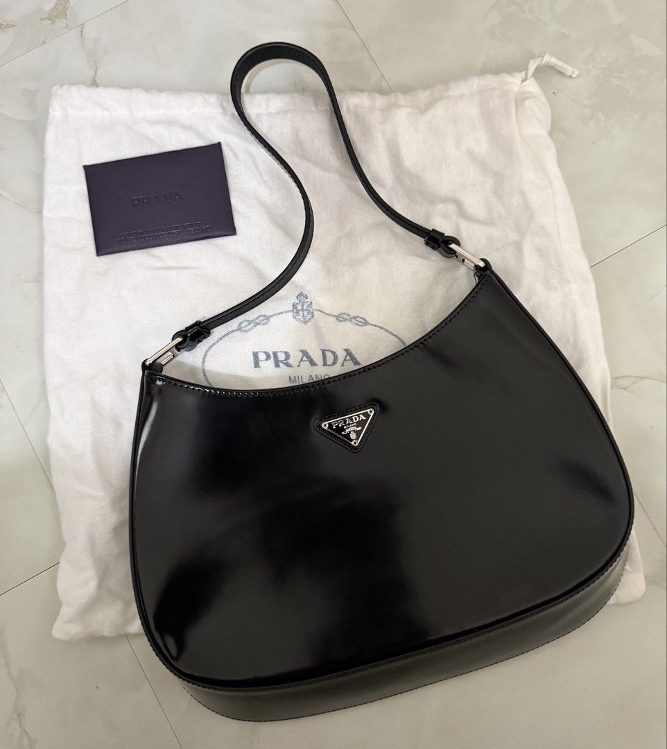Prada Cleo Hobo Bag Black Patent Leather (Category: Luxury Bags & Wallets) located in Cagayan de Oro. Submitted by megflores413 (Listing ID 1450337738, Image 2). Description: - Authentic Prada bag - Black patent leather - Classic hobo shape - Comes with dust bag and authenticity card - Great for everyday use or nights out - Minimal signs of wear - Clean interior - Silver hardware - Stitch logo fell off due to wear but can be stitched back.