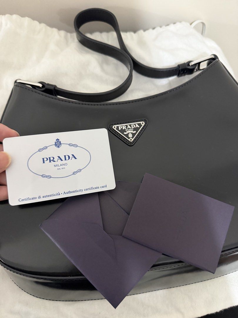 Prada Cleo Hobo Bag Black Patent Leather (Category: Luxury Bags & Wallets) located in Cagayan de Oro. Submitted by megflores413 (Listing ID 1450337738, Image 3). Description: - Authentic Prada bag - Black patent leather - Classic hobo shape - Comes with dust bag and authenticity card - Great for everyday use or nights out - Minimal signs of wear - Clean interior - Silver hardware - Stitch logo fell off due to wear but can be stitched back.