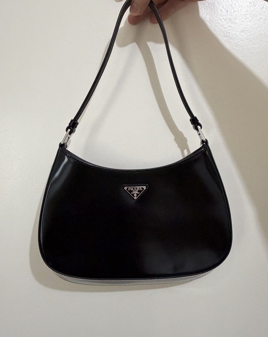 Prada Cleo Hobo Bag Black Patent Leather (Category: Luxury Bags & Wallets) located in Cagayan de Oro. Submitted by megflores413 (Listing ID 1450337738, Image 1). Description: - Authentic Prada bag - Black patent leather - Classic hobo shape - Comes with dust bag and authenticity card - Great for everyday use or nights out - Minimal signs of wear - Clean interior - Silver hardware - Stitch logo fell off due to wear but can be stitched back.
