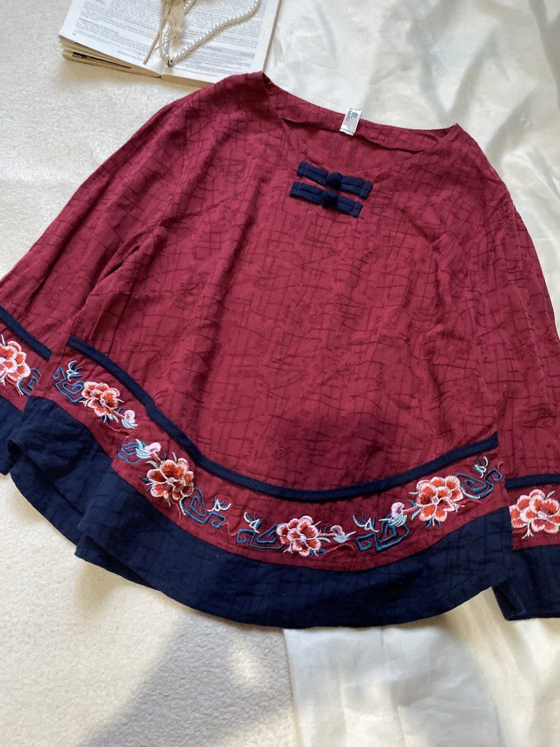 Red Embroidered Top with Chinese Knot Buttons Medium (Category: Blouses) located in Poro. Submitted by joyceyuu (Listing ID 1450523732, Image 2). Description: - Vibrant red top - Intricate floral embroidery on hem and sleeves - Traditional Chinese knot buttons at neckline - Loose, flowy silhouette - Versatile for casual or dressed-up occasions - Unique and eye-catching design.