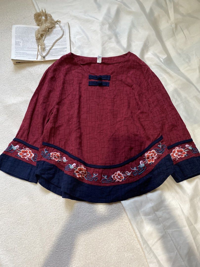 Red Embroidered Top with Chinese Knot Buttons Medium (Category: Blouses) located in Poro. Submitted by joyceyuu (Listing ID 1450523732, Image 1). Description: - Vibrant red top - Intricate floral embroidery on hem and sleeves - Traditional Chinese knot buttons at neckline - Loose, flowy silhouette - Versatile for casual or dressed-up occasions - Unique and eye-catching design.