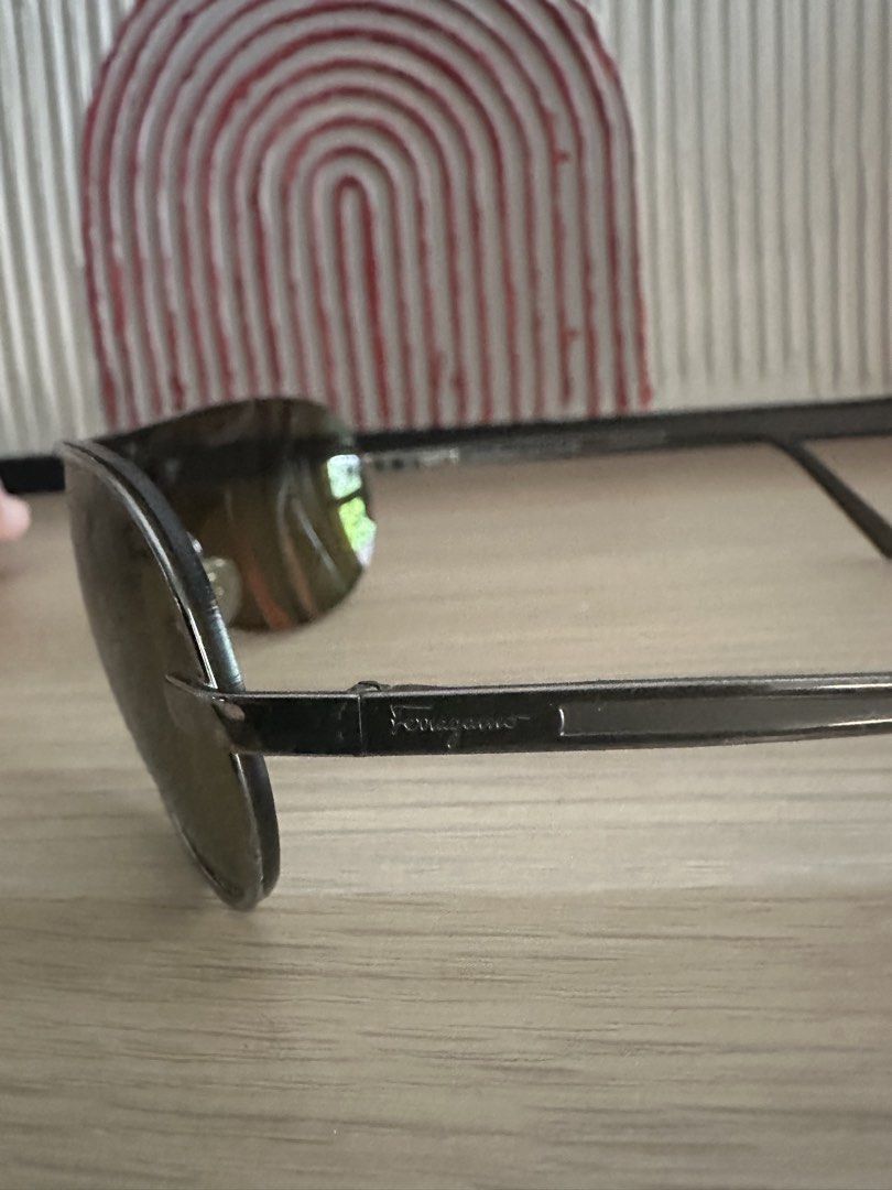 Salvatore Ferragamo Aviator Sunglasses (Category: Sunglasses & Eyewear) located in Quezon City. Submitted by heiressofpersia80 (Listing ID 1450351810, Image 3). Description: - Authentic Salvatore Ferragamo aviator sunglasses - Sleek silver frame - Dark tinted lenses for a classic look - Ideal for everyday wear Unisex Authentic pair of vintage S@lv@tore Ferr@gamo Model Number: 1094 Color Code: 502/73 metallic silver frame paired with Green or dark