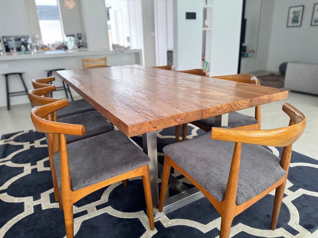 Solid Wood Dining Table (Category: Tables & Sets) located in Singapore. Submitted by localmarketboy (Listing ID 1450369158, Image 1). Description: - Solid wood dining table with unique textured top - Sturdy metal base - Seats 6-8 people comfortably - Includes 6 comfortable chairs with grey upholstered seats - Wooden chair frames - Perfect centerpiece for your dining room - Ideal for family meals and entertaining guests Custom Solid Wood Dining Ta